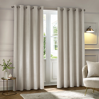 Neptune Eyelet Curtains in Ivory over a window image