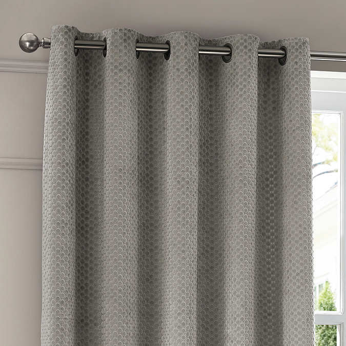 Neptune Eyelet Curtains in Silver over a window close up image