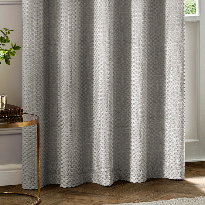 Neptune Eyelet Curtains in Silver over a window close up image