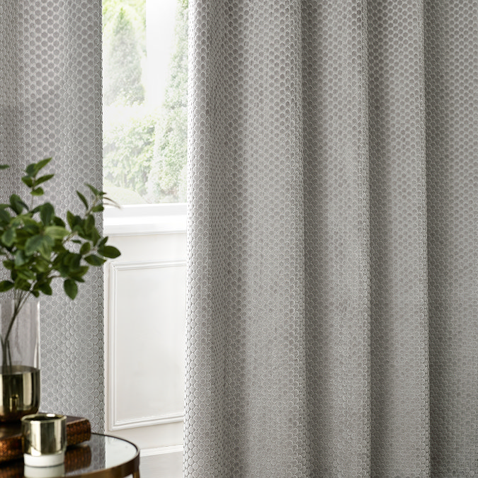 Neptune Eyelet Curtains in Silver over a window close up image