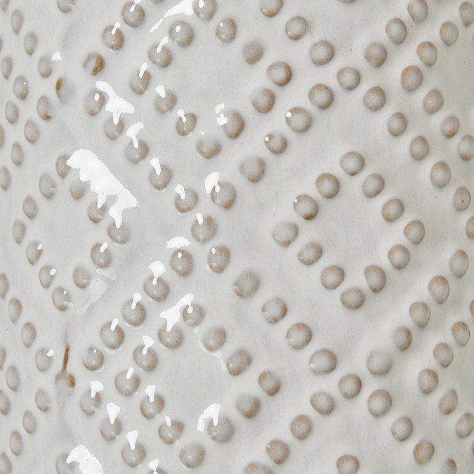 close up image of beaded detail on white ceramic vase