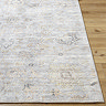 close up on corner of floral grey and beige rug on wooden flooring