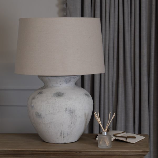 large ceramic table lamp on top of a wooden chest of drawers