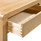 close up image of light wooden desk with drawer open to show trolley open/close function.