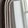 close up image of soft grey frame of decorative overmantle mirror