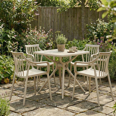 image of putty grey coloured square plastic dining table with matching chairs on stone corner of garden