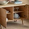 close up on inside of light oak sideboard, two doors open to show four shelving spaces with crockery and glassware inside
