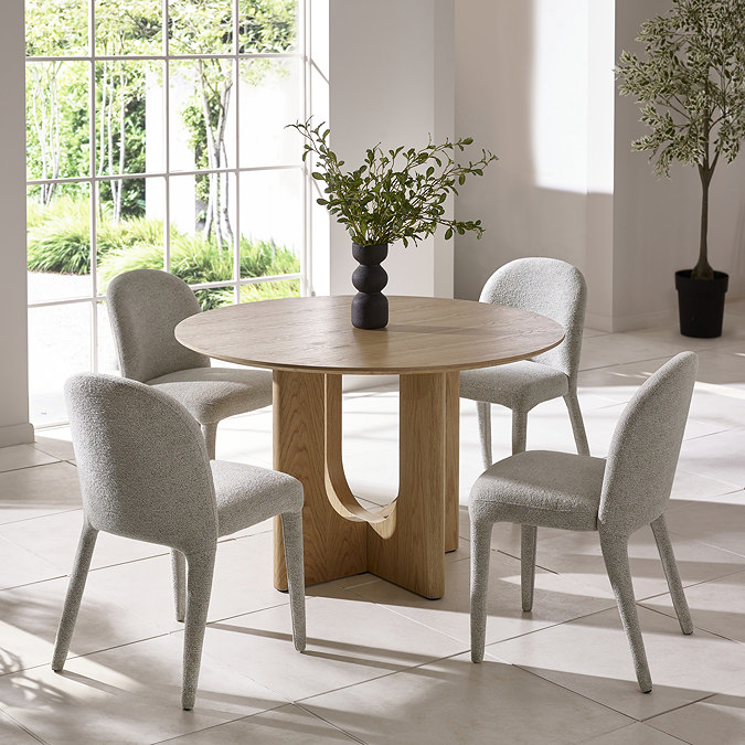 image of four grey chenille chairs around a round oak table on cream tiled dining room floor