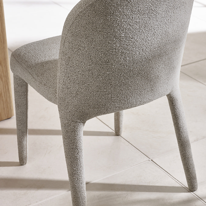 image taken from behind of grey chenille dining chair back with upholstered legs