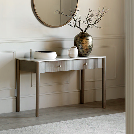 image of mango wood fluted console table topped with white marble, against a cream wall with decorative vases atop it, with mirror hanging above