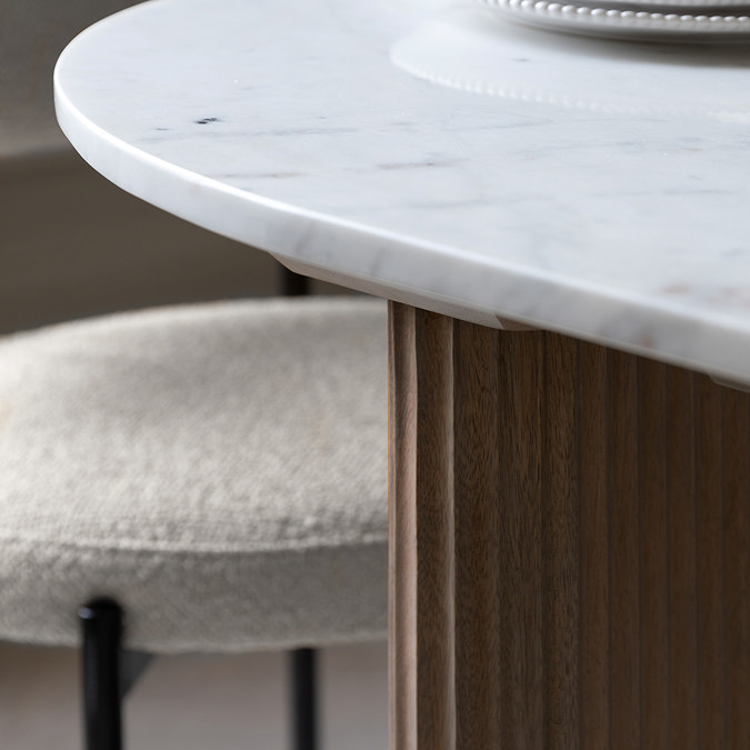 close up image of marble tabletop of mango wood dining table, highlighting unique blue-grey veins and rounded edge