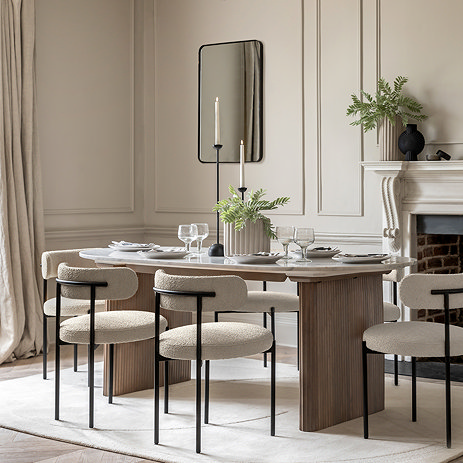 image of oval dining table with marble top and ribbed mango wood legs, with modern dining chairs tucked around it
