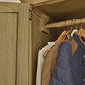 close up on inside of classic oak wardrobe with clothes hanging up, focus on hinges