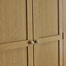 close up image on closed doors of classic oak wardrobe with small delicate metal handles