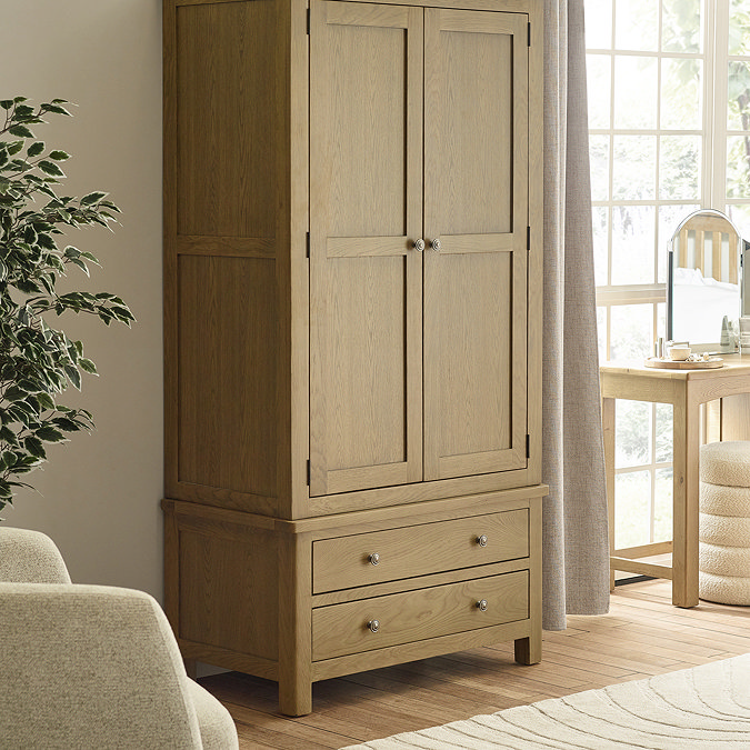 image of solid oak wardrobe with 2 doors and 2 drawers, stood tall in bedroom on wooden flooring