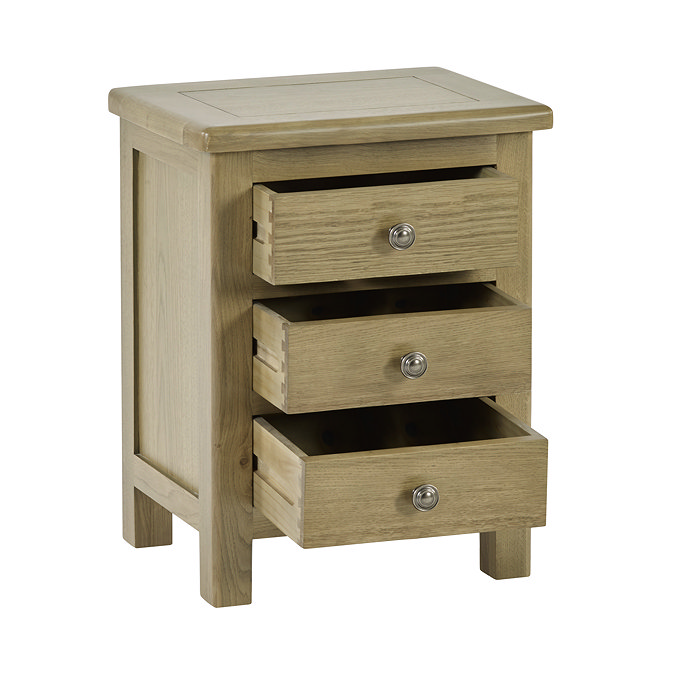 image cut out on white background of solid oak bedside table with three drawers open