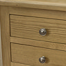 close up image of solid oak front and small round metal handles of three drawer bedside table