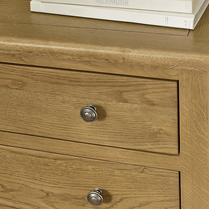 close up image of solid oak chest of drawers with small round handles