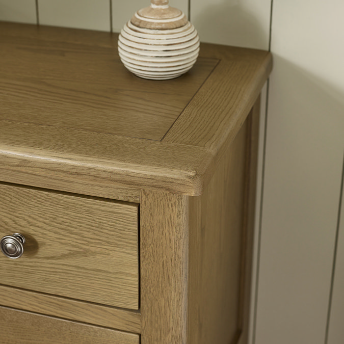 close up image of smooth oak top of chest of drawers