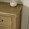 close up image of smooth oak top of chest of drawers
