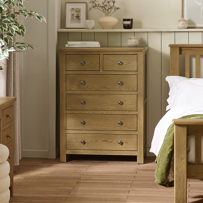 image of solid oak six drawer chest next to matching bed in modern country style home