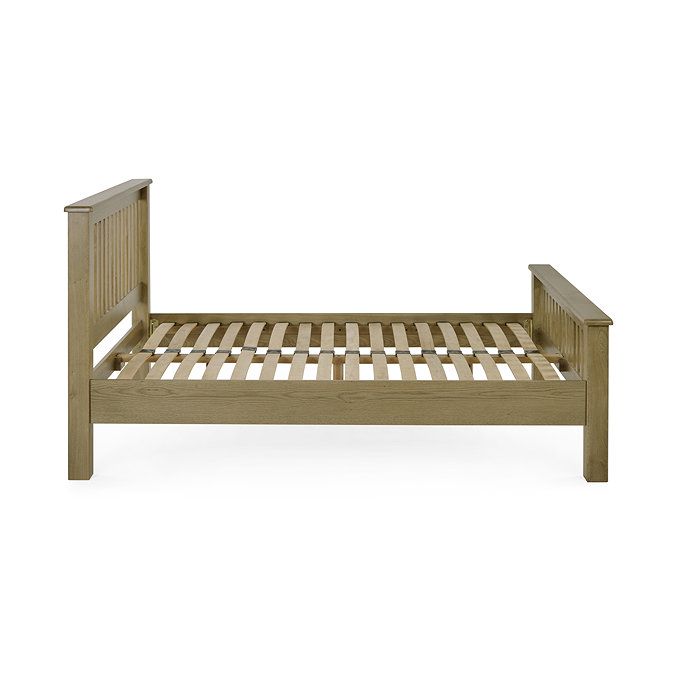 side on image cut out on white background of solid oak slatted bed without mattress