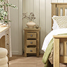 image of three drawer slim bedside table with drawers open, next to matching bed