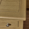 close up image of smooth oak top of bedside table with round metal knob