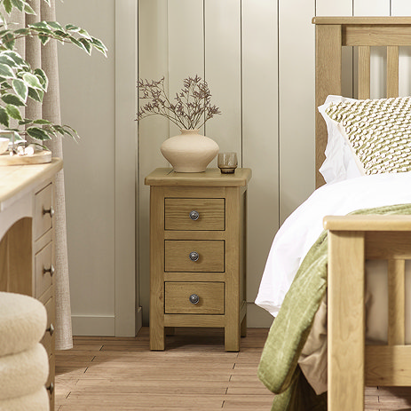 image of slim three drawer bedside table next to matching bed in modern country bedrooms