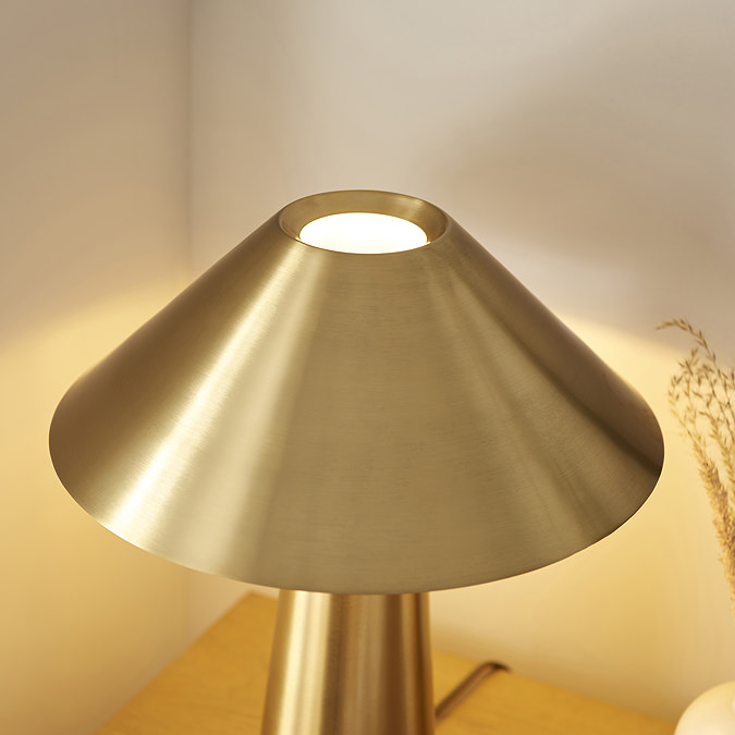 close up on conical shade of brushed brass table lamp with slim base