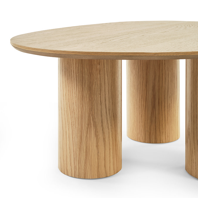 close up image cut out on white background of rounded oak coffee table with pillar legs, highlighting wood grain effect in the legs