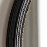 close up image of black round wall mirror with gold inner trim detailing