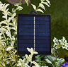 close up image of solar panel for pine cone string lights, in a bush