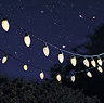 image of pine cone shaped string lights glowing warm white at night with starry sky