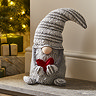 plush grey gonk santa holding small red heart, sat at the bottom of the fireplace