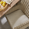 close up image on neutral coloured cushion of rattan garden dining chair