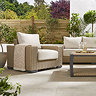 close up image of chunky rattan garden armchair with cream cushion