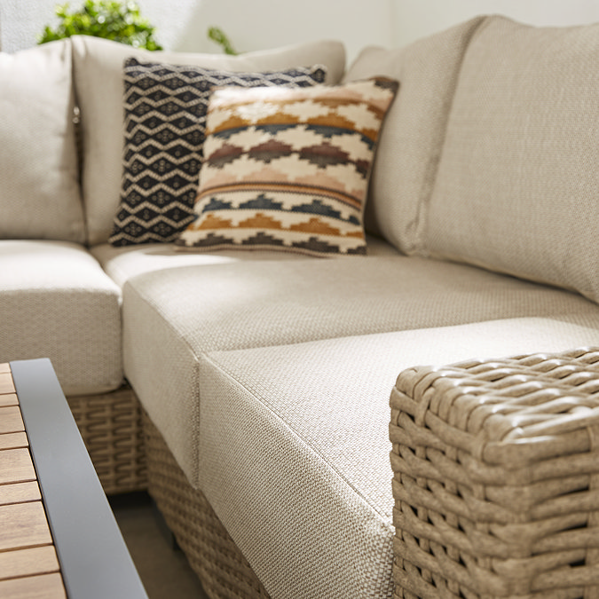 close up image of deep cream cushions set in chunky rattan frame of outdoor corner lounge set