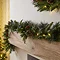close up image of cranberry and pine garland draped on a light oak mantlepiece