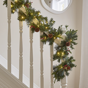 cranberry and pine garland wrapped around a bannister