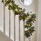 cranberry and pine garland wrapped around a bannister