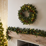 image of cranberry wreath hung above a mantlepiece with the matching garland draped below it