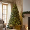 pre-lit lush pine tree with warm white LEDs stood in the middle of cosy living room