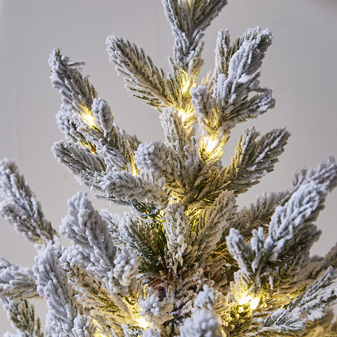 close up image of snowy branches, lit with tiny warm white LEDs