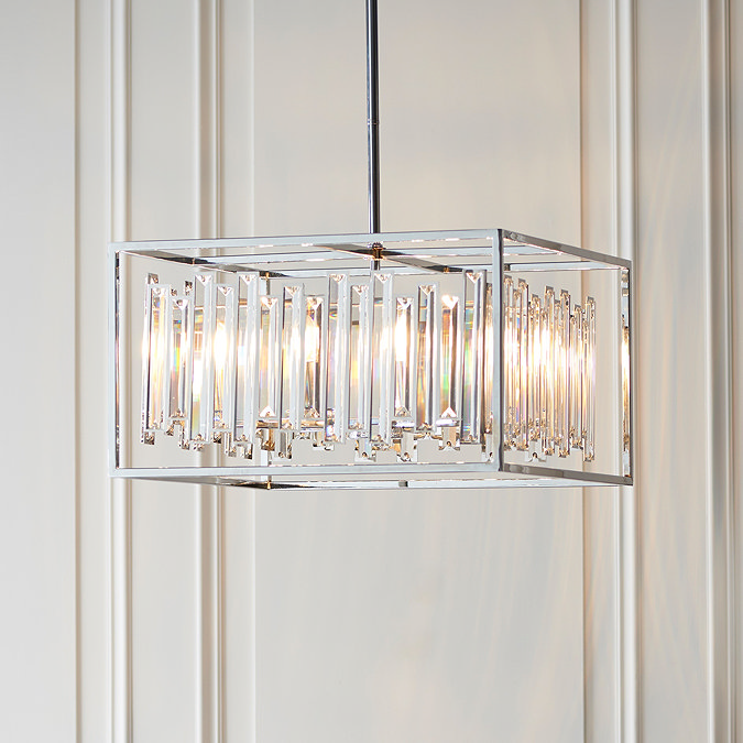 image of rectangular chrome ceiling light frame with bevelled glass within, obscuring the size candle-capped bulbs emitting warm light