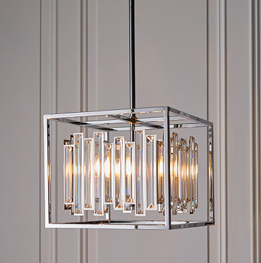 close up image of chrome metal framework of hanging pendant light with abstract glass refracting warm light from within