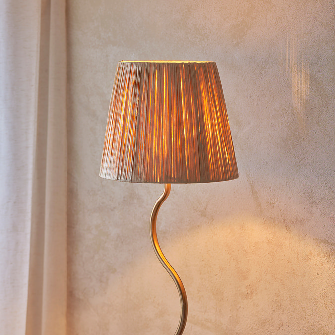 close up on top of lamp with textured shade and wriggle-shaped brass body