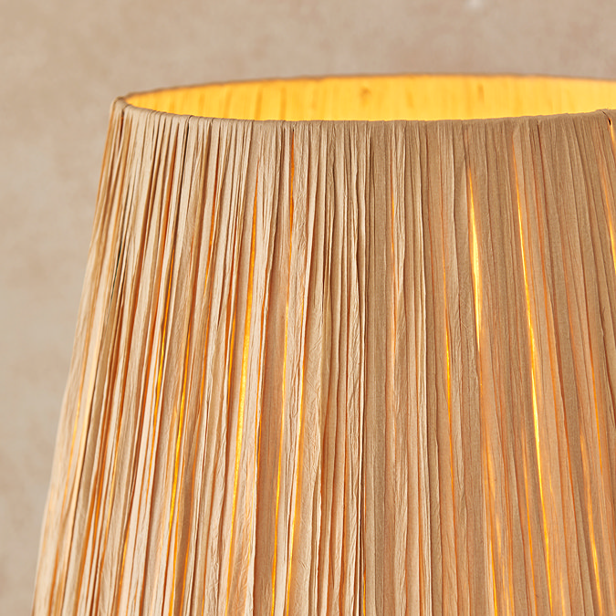 close up image of textured shade of light with bulb emitting warm glow
