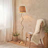 image of floor lamp with wiggle shaped brass body and textured shade