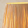 close up on raffia lamp shade of wriggle floor lamp emitting warm glow